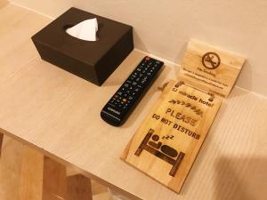a remote control and a box on a table at SJ Miracle Hotel in Hat Yai