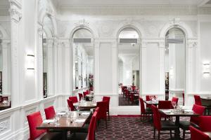 una sala da pranzo con tavoli e sedie rosse di Club Quarters Hotel Times Square, New York a New York