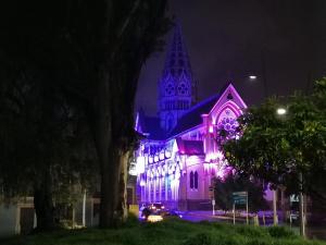 una iglesia iluminada en púrpura con una catedral en Hotel LB - Los Balsos, en Pasto