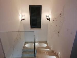 Un escalier avec deux lumières et un miroir mural dans l'établissement Lovely 2-Bed Apartment in Drenje near Rabac, à Labin