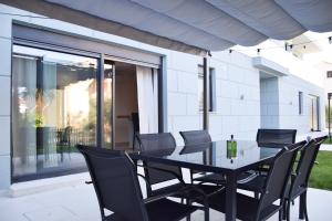 Une table à manger et des chaises noires sont disponibles sur la terrasse. dans l'établissement Lovely 2-Bed Apartment in Drenje near Rabac, à Labin