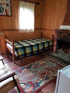 a room with a bed and a fireplace at A Casinha Pequenina in Monte Verde