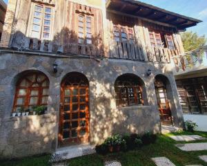 an old stone building with windows and a balcony at Hotel Ariana in San Pedro La Laguna