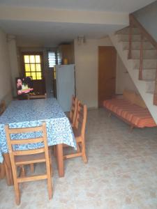 une salle à manger avec une table, des chaises et un escalier dans l'établissement Duplex cerca del Mar en Las Toninas, à Las Toninas