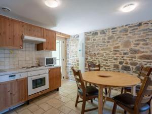 uma cozinha com uma mesa de madeira, uma mesa e cadeiras em Cottage around a swimming pool in a small villa em Courry