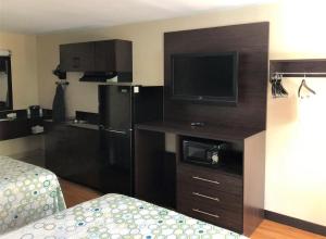 a hotel room with a television and a bed in a room at HomeTowne Studios by Red Roof Bordentown - McGuire AFB in Bordentown