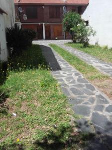 un camino de piedra frente a una casa en Duplex cerca del Mar en Las Toninas en Las Toninas