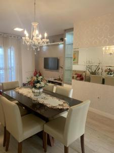 Una mesa de comedor con sillas y un comedor. en Apto 3 dorm completo - 100m Praia - Meia Praia, en Itapema