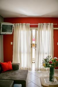 a living room with a couch and a tv at Hotel Palugi in Joinville
