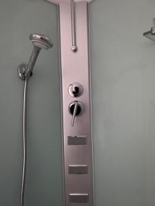 uma porta de duche com uma cabeça de chuveiro na casa de banho em Gwladys's Home em Aywaille