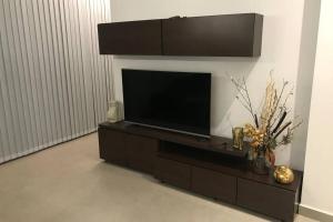 a living room with a flat screen tv on a entertainment center at Vivienda con hermosas vistas, al pie del cerro in Yerba Buena