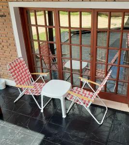 two chairs and a table on a porch at Hostería Tejas Negras in Mina Clavero