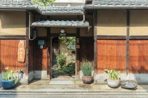 a building with potted plants in front of a door at Toshiharu Ryokan in Kyoto