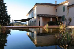 a building with a pool of water in front of it at La Maison R in Pignans