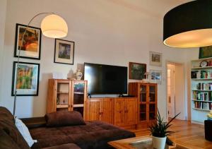 a living room with a couch and a flat screen tv at Nana-EG-80m2 sanierter Altbau-Parkplatz-kleiner Garten-WLAN-NETFLIX-2Zimmer-Küche-Dusche-Wanne-Waschmaschine in Oberhausen