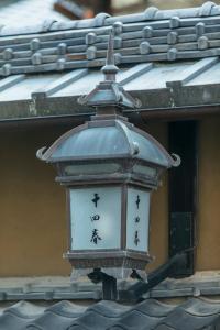 a clock on the side of a building at Toshiharu Ryokan in Kyoto