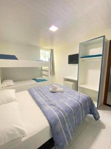 a white bedroom with a bed with a blue blanket at Pousada Coração do Parque in Penha +14 photos