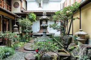 a garden with a fountain in the middle of a building at Toshiharu Ryokan in Kyoto