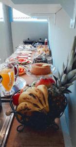a table topped with plates of food and fruit at Pousada Coração do Parque in Penha