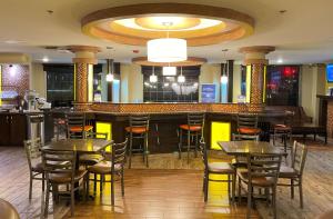 a bar in a restaurant with tables and chairs at Best Western Aspen Hotel in Fort Smith