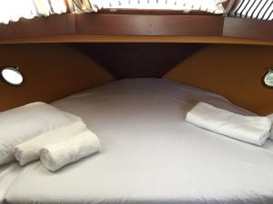 Bett in einem Zimmer mit zwei Kissen darauf in der Unterkunft Home Boat in Badalona
