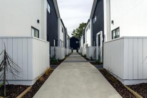 a walkway between two white buildings at Armagh 221 - Christchurch Holiday Homes in Christchurch