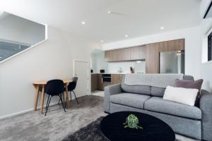 a living room with a couch and a table at Armagh 221 - Christchurch Holiday Homes in Christchurch