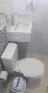 a bathroom with a white toilet and a sink at Pousada Coração do Parque in Penha