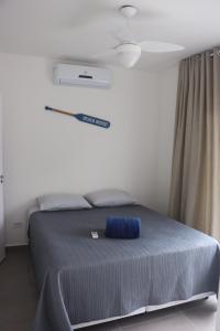 une chambre avec un lit avec un oreiller bleu dessus dans l'établissement Casa de Condomínio em Maresias - Pertinho da praia, à Maresias 31 autres photos