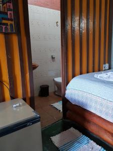 a bedroom with a bed and a toilet in it at A Casinha Pequenina in Monte Verde