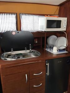 a kitchen with a sink and a microwave at Home Boat in Badalona