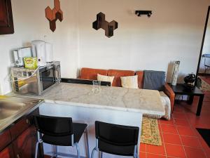 a kitchen with a counter with chairs and a couch at Óbidos - Casa do Castelo in Óbidos