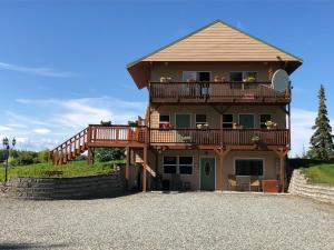 ein großes Haus mit einem Balkon und einer Terrasse in der Unterkunft McKinley View B&B in Trapper Creek