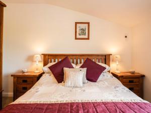 UgthorpeにあるFairhaven Cottageのベッドルーム1室(大型ベッド1台、紫色の枕付)