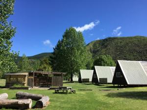 a group of lodges in a field with a picnic table at Mohaka River Farm in Te Haroto