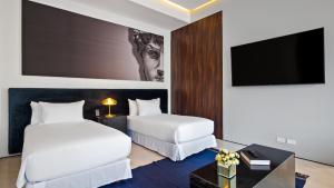 a hotel room with two beds and a flat screen tv at PIER 57 - 709 Stunning View 2 BR Romantic Zone in Puerto Vallarta