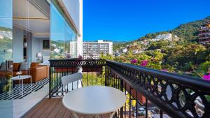 a balcony with a table and a view of a city at PIER 57 - 709 Stunning View 2 BR Romantic Zone in Puerto Vallarta