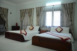 DTC Hotel في دا نانغ: غرفة فندقية بسريرين ونافذة