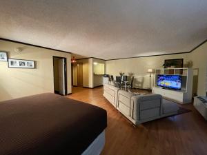 a hotel room with a bed and a flat screen tv at Abilene Whitten Inn in Abilene