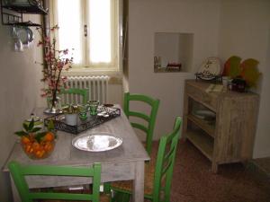 una mesa de comedor con sillas verdes y una mesa con naranjas. en B&B Antico Aranceto, en Bagnolo del Salento