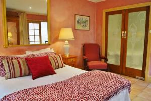 1 dormitorio con cama, silla y espejo en North Adelaide Heritage Cottages & Apartments en Adelaida
