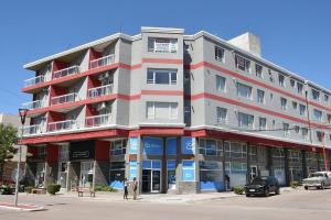 Un gran edificio de apartamentos en la esquina de una calle. en Departamento Piamonte, en Monte Hermoso