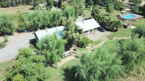 eine Luftaufnahme eines Hauses mit Pool und Bäumen in der Unterkunft Cabañas de Campo Colbún in Colbún