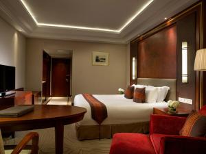 杭州市にあるソフィテル 杭州 ウエストレイクの大きなベッドとデスクが備わるホテルルームです。