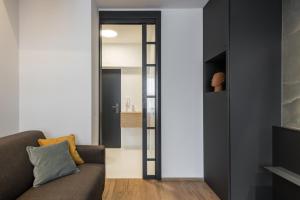 プラハにあるFully renovated stylish duplex in a convenient locationのリビングルーム(ソファ付)、ガラスの引き戸