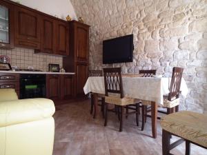 a kitchen with a table and chairs and a tv at Anticu Dammusu in Scicli