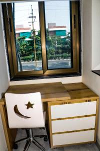 escritorio con silla y ventana en Stay10 Studio Apartments en Indore