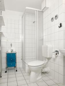 a white bathroom with a toilet and a shower at Mann un Fru - Residenz am Yachthafen in Kirchdorf