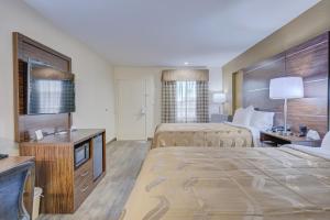 サフォークにあるQuality Inn & Suitesのベッド2台とテレビが備わるホテルルームです。