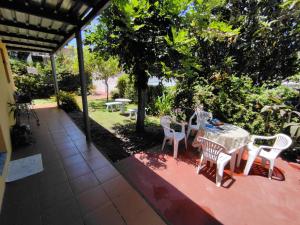 un patio con mesa, sillas y árboles en Paulina y Emma - confortable apartamento, en Santa Ana